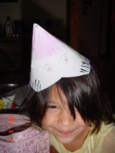 Olivia makes birthday hat.